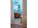 Bright bathroom with white tiled floors, single sink vanity, framed mirror, and toilet at 189 Minniehaha Cir, Haines City, FL 33844