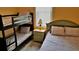 Bedroom featuring a full-sized bed, twin bunk beds, neutral patterned bedding and wood-look floors at 189 Minniehaha Cir, Haines City, FL 33844