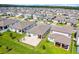 High-angle shot of a residential area featuring homes with manicured lawns and patios, all under a bright, clear sky at 2296 Crossbow St, Clermont, FL 34715