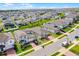 Aerial view of a suburban neighborhood with homes featuring brick driveways and green lawns under a bright, clear sky at 2296 Crossbow St, Clermont, FL 34715