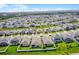 An aerial view shows rows of houses in a community with well-maintained lawns and landscaping, set against a clear sky at 2296 Crossbow St, Clermont, FL 34715