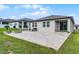 Backyard featuring a concrete patio with a fire pit, seating, and ample green space at 2296 Crossbow St, Clermont, FL 34715