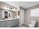 Bathroom featuring a double vanity with granite countertops, grey cabinets, and a toilet at 2912 Fletcher Ave, Lakeland, FL 33803