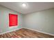 Empty bedroom featuring wood-look floors, light-green walls, and a red window covering at 2912 Fletcher Ave, Lakeland, FL 33803