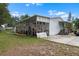 House exterior featuring a wooden deck and stairs with overgrown lawn at 2912 Fletcher Ave, Lakeland, FL 33803
