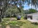 View of a white home with a deck and yard featuring mature trees at 2912 Fletcher Ave, Lakeland, FL 33803
