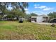 White house and shed with trees and a vehicle parked outside at 2912 Fletcher Ave, Lakeland, FL 33803