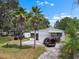 Charming single-story home with a cozy front porch, palm trees, and a spacious driveway at 2912 Fletcher Ave, Lakeland, FL 33803