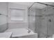 Modern bathroom featuring a soaking tub and glass-enclosed shower with neutral tiling at 4217 Kingbird Ct, Orlando, FL 32826