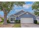 Charming blue single-story home with a well-manicured lawn and a two-car garage at 4217 Kingbird Ct, Orlando, FL 32826