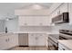 Modern kitchen with white cabinets, stainless steel appliances, and ample counter space at 4217 Kingbird Ct, Orlando, FL 32826
