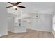 Open-concept living space with wood floors, fan, and modern lighting flowing into the kitchen at 4217 Kingbird Ct, Orlando, FL 32826