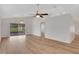 Expansive living room with vaulted ceiling, fan, wood floors, and access to the screened in lanai at 4217 Kingbird Ct, Orlando, FL 32826