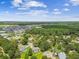 Wide-angle aerial view displays residences, a network of trees, and calm ponds under a partly cloudy sky at 4221 Meadowbend Ct, Lakeland, FL 33811