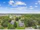 Aerial view showcases a house with a screened pool amidst a lush, tree-filled neighborhood at 4221 Meadowbend Ct, Lakeland, FL 33811