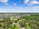Sprawling overhead view presents homes, serene ponds, and lush trees against a backdrop of a partly cloudy sky at 4221 Meadowbend Ct, Lakeland, FL 33811