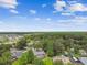 Scenic aerial view of a neighborhood surrounded by lush greenery and blue skies at 4221 Meadowbend Ct, Lakeland, FL 33811