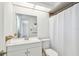 Bright white bathroom features a vanity and shower with white curtain at 4221 Meadowbend Ct, Lakeland, FL 33811