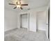 This bedroom features neutral carpet, a ceiling fan, and closet with open doors at 4221 Meadowbend Ct, Lakeland, FL 33811