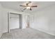 This bedroom features neutral carpet, a ceiling fan, and closet with open doors at 4221 Meadowbend Ct, Lakeland, FL 33811