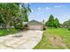 Home with a long driveway, brick facade, well-kept lawn, and mature trees on a sunny day at 4221 Meadowbend Ct, Lakeland, FL 33811