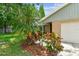 Close-up of home's exterior featuring colorful landscaping and a partial view of the garage at 4221 Meadowbend Ct, Lakeland, FL 33811