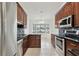 Modern kitchen featuring dark cabinets, stainless steel appliances, and tile flooring at 4221 Meadowbend Ct, Lakeland, FL 33811