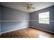 Cozy bedroom with hardwood floors, neutral gray walls, and a ceiling fan at 1920 E Edgewood Dr # E1, Lakeland, FL 33803