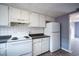 Clean kitchen featuring white cabinets, appliances, and tile backsplash at 1920 E Edgewood Dr # E1, Lakeland, FL 33803