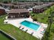 Aerial view of community pool surrounded by chairs and lush landscaping at 1920 E Edgewood Dr # E1, Lakeland, FL 33803