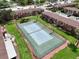 Aerial view of community tennis courts surrounded by green space and condo buildings at 1920 E Edgewood Dr # E1, Lakeland, FL 33803