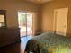 Bedroom with a blue patterned quilt and a patio view at 314 Lake Butler Dr, Kissimmee, FL 34759