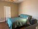 Comfortable bedroom with blue patterned quilt, ceiling fan, and wood floors at 314 Lake Butler Dr, Kissimmee, FL 34759