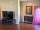 Open living area with laminate flooring, TV, cabinet, picture and door at 314 Lake Butler Dr, Kissimmee, FL 34759