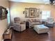 Cozy living room with a ceiling fan, wood floors, and large windows at 314 Lake Butler Dr, Kissimmee, FL 34759