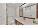 Bathroom with a large mirror, white sink and toilet, and shower with curtain and grab bars at 454 San Jose Dr, Winter Haven, FL 33884