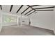 Living room featuring vaulted ceilings, exposed beams, and view of backyard at 454 San Jose Dr, Winter Haven, FL 33884