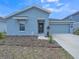 Charming exterior of home featuring a front yard with a well maintained lawn, bushes and mulch at 621 Silver Palm Dr, Haines City, FL 33844