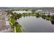 Picturesque aerial view of a serene lake community with walking paths, trees, and modern buildings at 12684 Willstatter Ave, Orlando, FL 32827