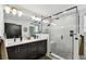 Modern bathroom featuring double vanity, and a walk-in shower with glass door and gray tile at 12684 Willstatter Ave, Orlando, FL 32827