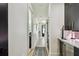 Hallway with white walls and hardwood floors leads to a black door at 12684 Willstatter Ave, Orlando, FL 32827