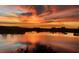 Stunning sunset over a serene lake, reflecting vibrant colors and silhouetted buildings in the distance at 12684 Willstatter Ave, Orlando, FL 32827