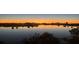 Picturesque lake view at sunset, featuring vibrant colors reflected in the calm waters with city skyline at 12684 Willstatter Ave, Orlando, FL 32827
