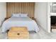 Bedroom with wood panel accent wall, decorative trunk, and contemporary furnishings at 12684 Willstatter Ave, Orlando, FL 32827