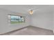 Empty bedroom with a ceiling fan, neutral carpet and view of the property at 3582 Milano Ave, Lakeland, FL 33803