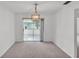 Carpeted dining room with stylish light fixture and patio access at 3582 Milano Ave, Lakeland, FL 33803