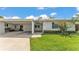 The front exterior features lush green grass, a covered carport, and beautiful flowering bushes at 3582 Milano Ave, Lakeland, FL 33803