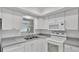 Bright kitchen featuring white cabinets, appliances, double sink and window at 3582 Milano Ave, Lakeland, FL 33803