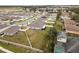 Neighborhood aerial view showcases homes with fenced yards and community featuring a lake and open fields at 389 Singing Sands Cir, Lake Wales, FL 33859