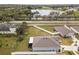 Aerial view of a home featuring a fenced perimeter, enclosed lanai, and a view of the nearby lake and highway at 389 Singing Sands Cir, Lake Wales, FL 33859